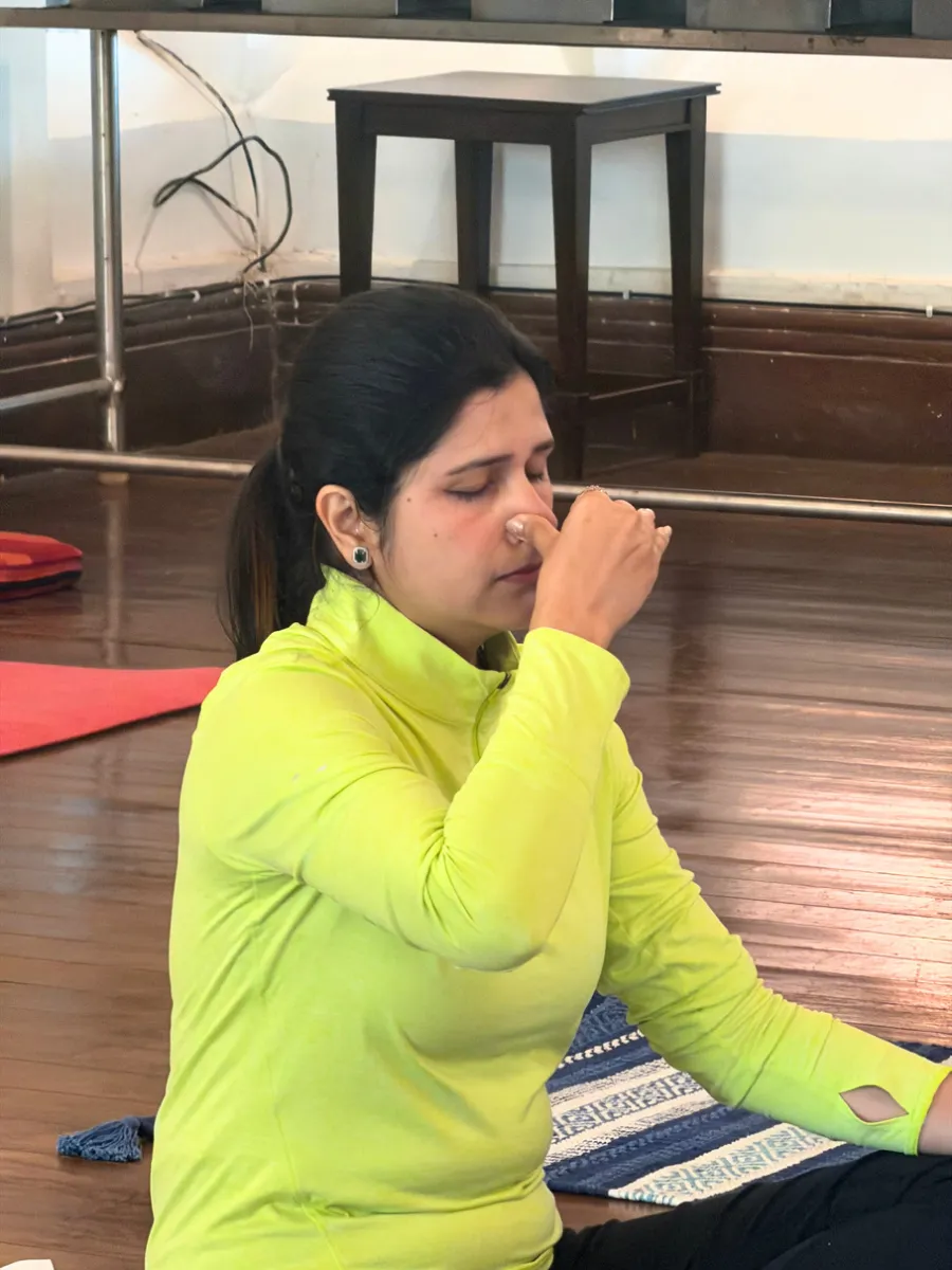 A participant practising alternate-nostril breathing in the club hall